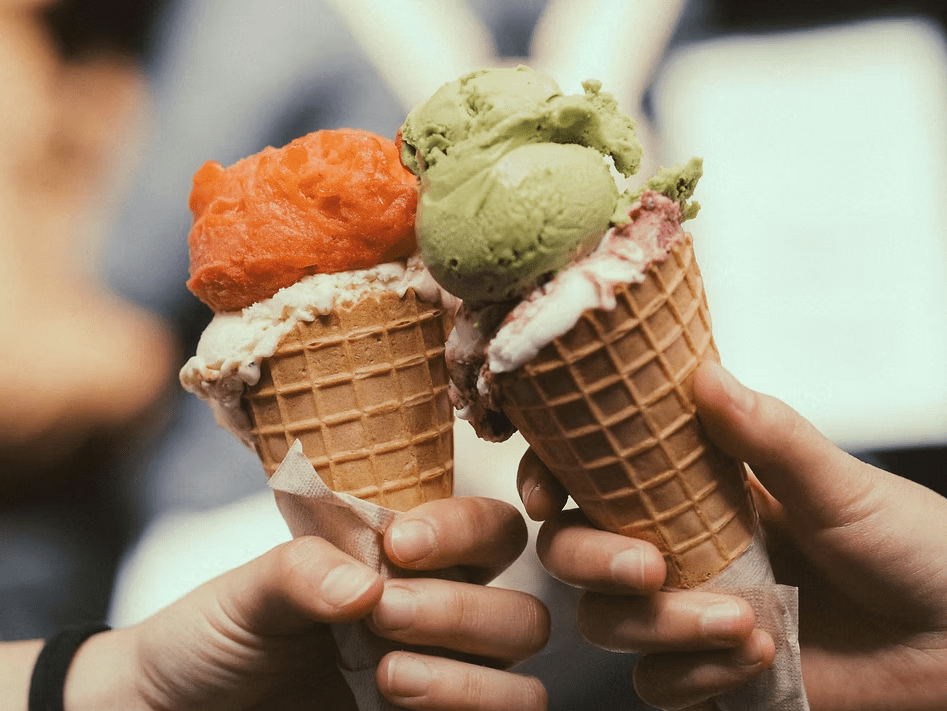 Two hands holding up gelato cones